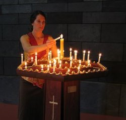 Donna che accende delle candele in una chiesa